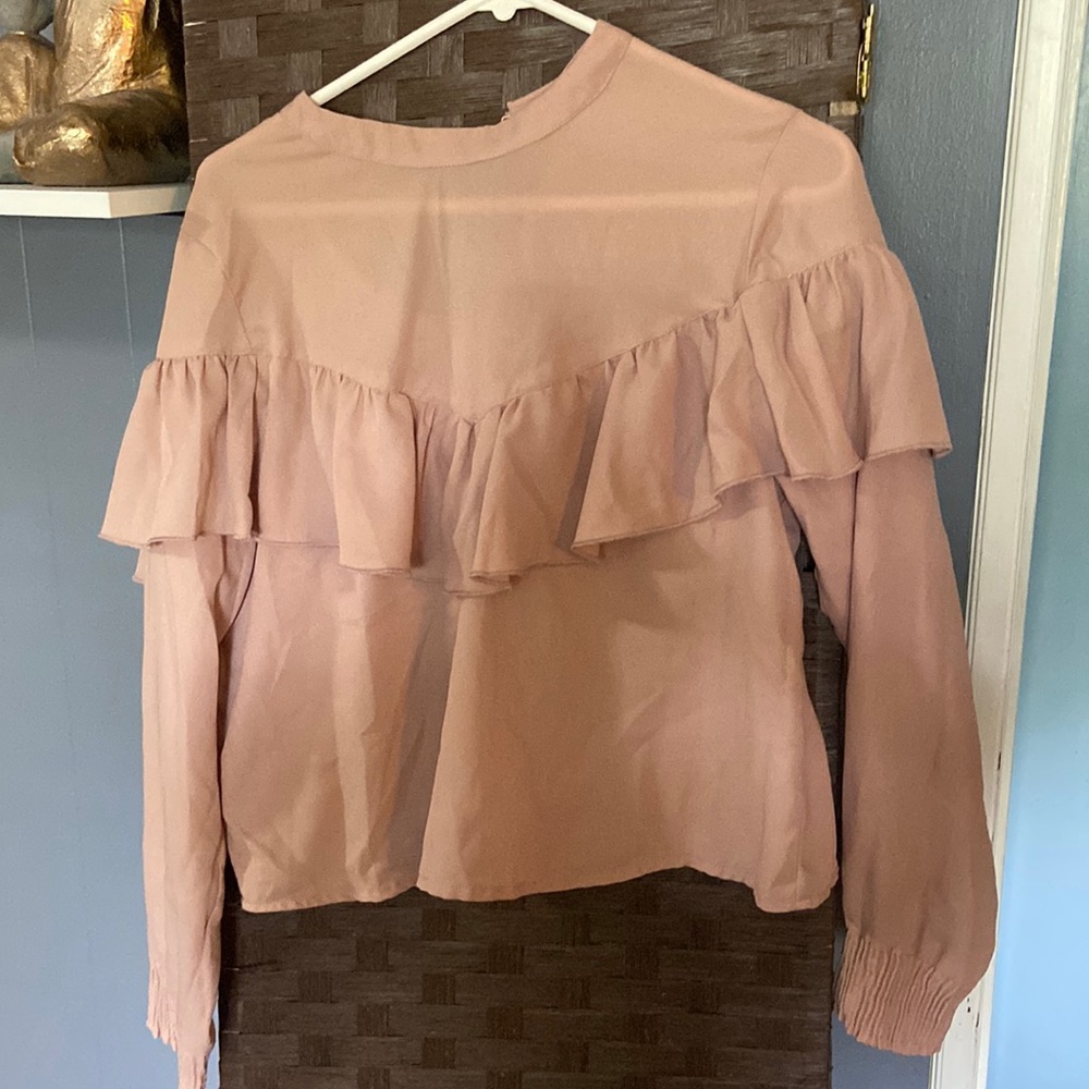 Cute ruffled top. Fits like a large. Arms are cuffed